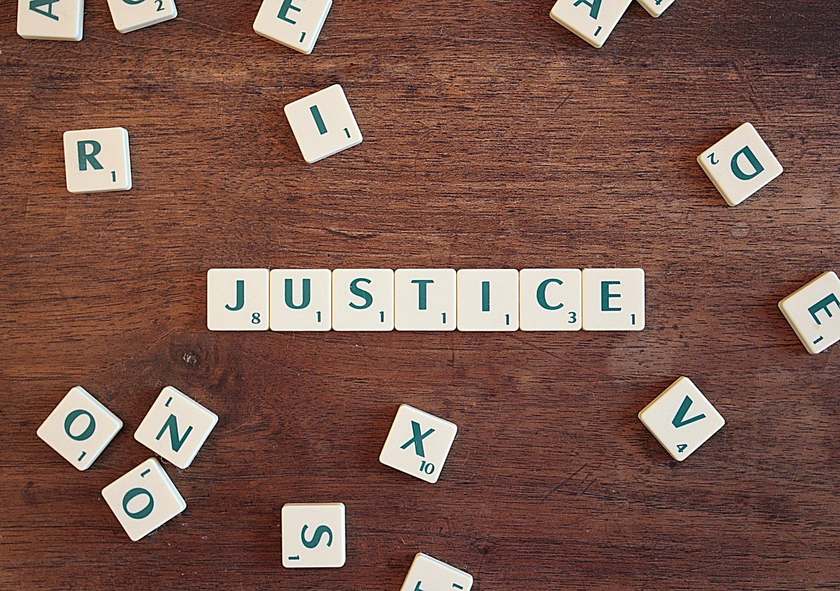 Scrabble avec le mot JUSTICE sur une table en bois Scrabble avec le mot JUSTICE sur une table en bois