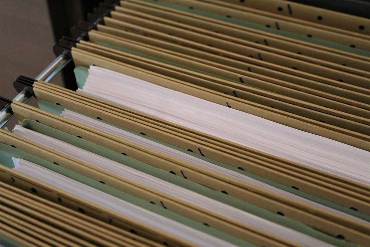 Classeur ouvert contenant des dossiers suspendus et documents blancs organisés